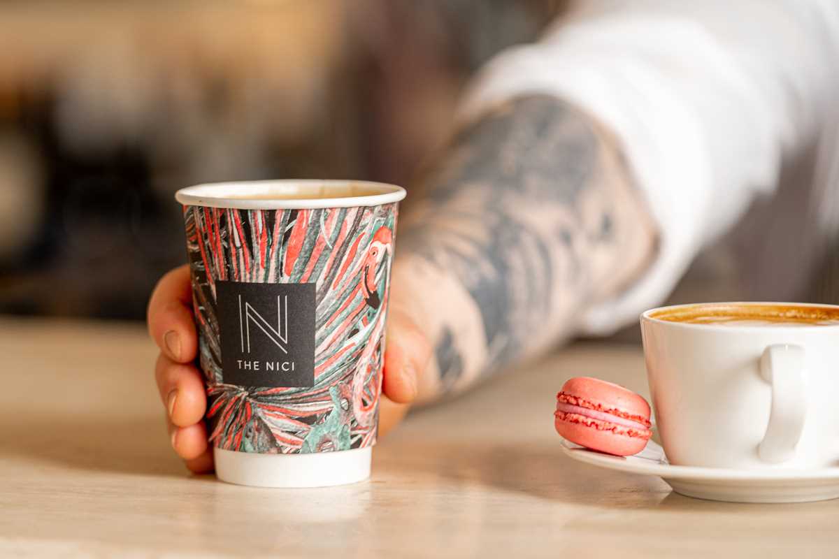 A Nici branded coffee takeaway cup